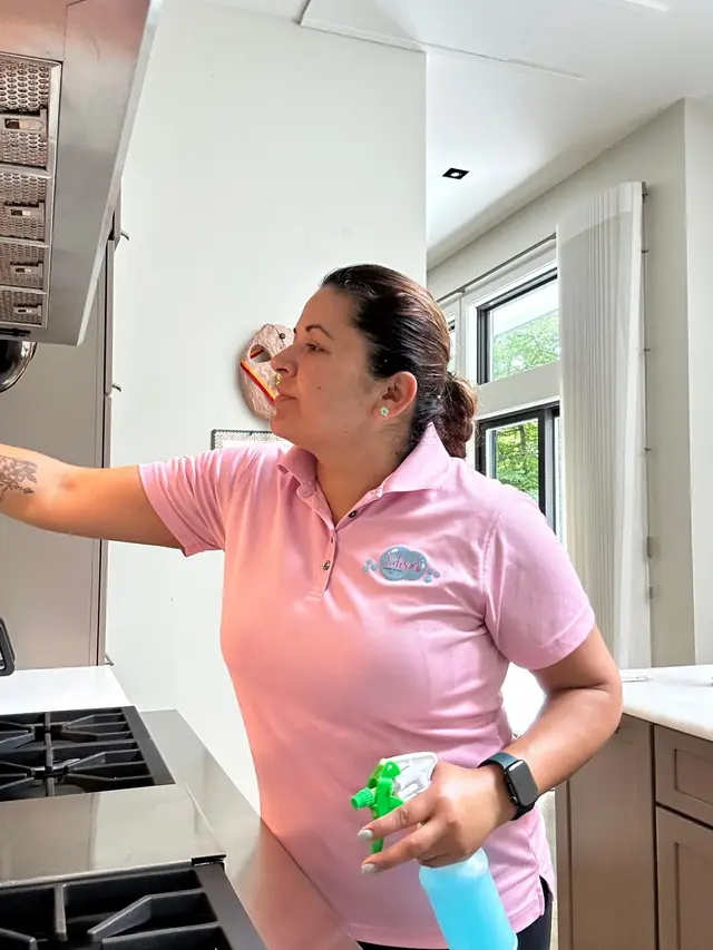 Cleaner degreasing a kitchen range hood during a deep clean